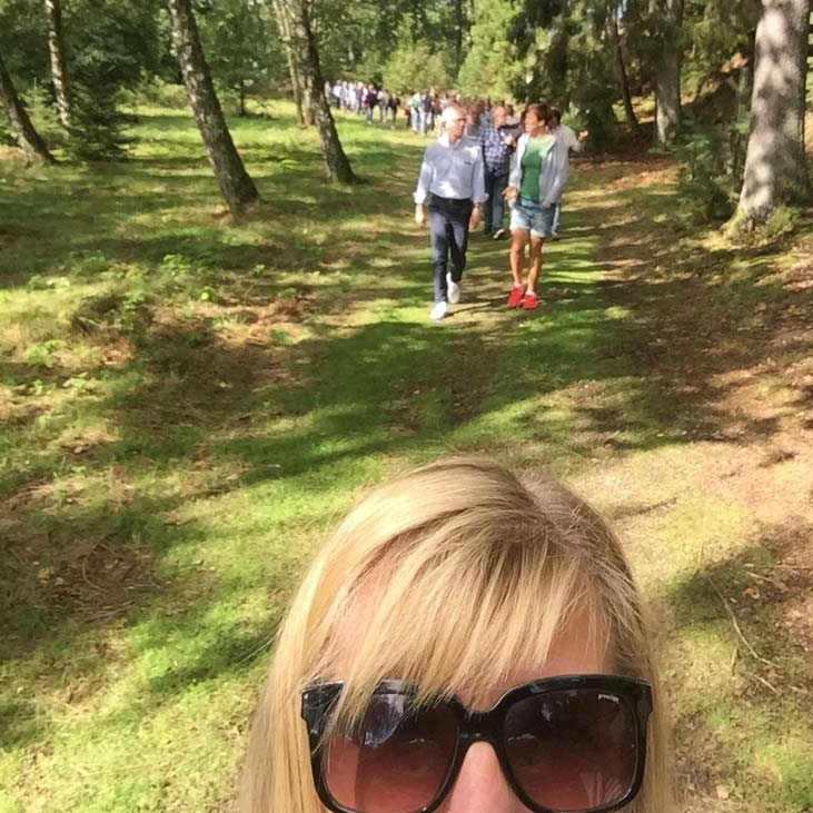 Brainwalk-selfie: övre delan av Malins huvud i nederkant, bakom henne parvis vandrande personer